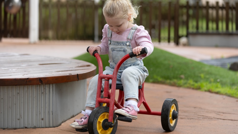 Child riding bike in QEC sensory garden.