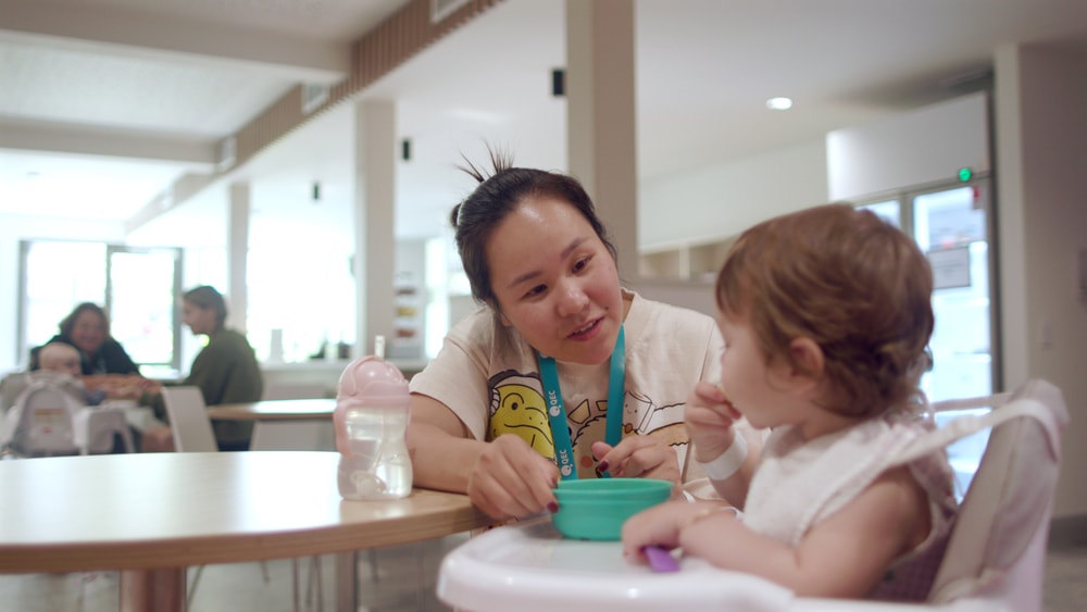 Parent Feeding Children in Dining Room