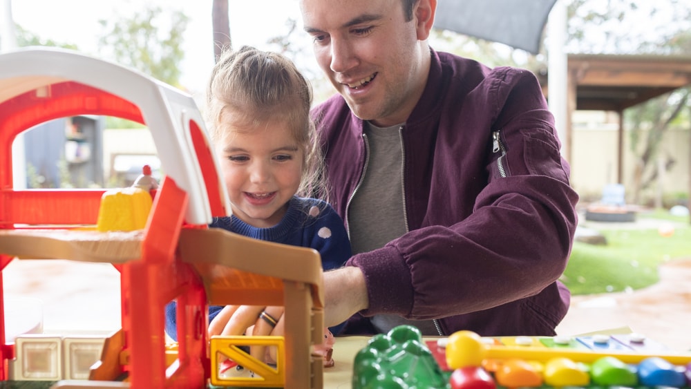 Dad playing with toys with child.