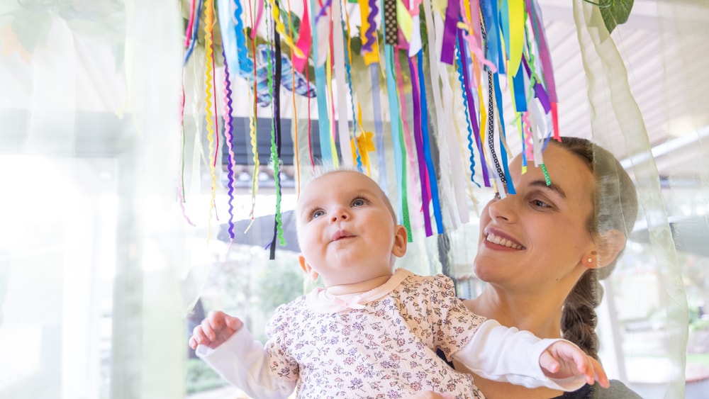 Baby enjoying sensory corner in QEC PlayRoom.