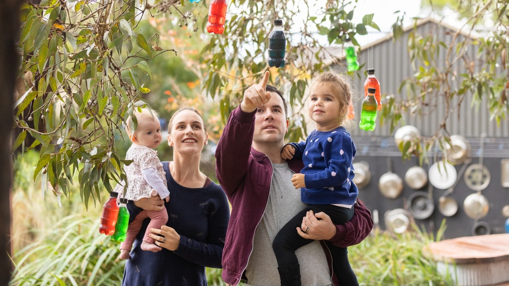 Family of four enjoying the QEC sensory garden together.