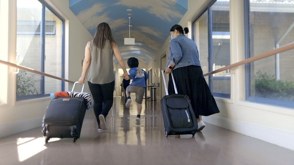 Parent and child walking with clinician to QEC Residential Unit.