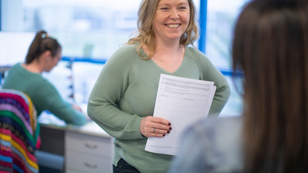 Staff member smiling talking to collegue