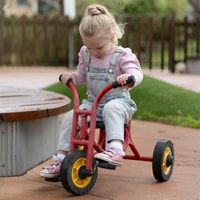 Child riding bike in QEC sensory garden.