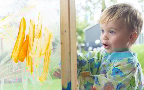 Child painting in QEC PlayRoom