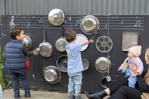 Children playing with pots and pans in the QEC sensory garden.