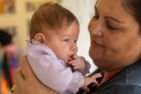 Parent holding baby up and looking into baby