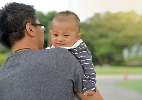 Father holding baby over shoulder