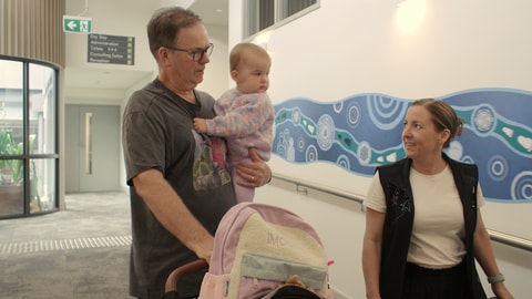 QEC Clinician walking dad holding baby down to Residential unit